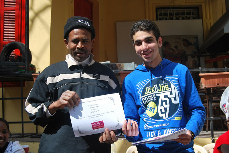 MWTF volunteer handing out langauge learing certificates to migrant worker