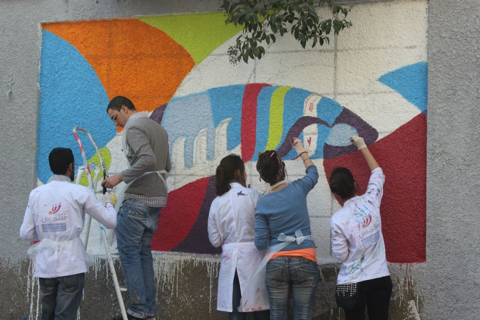 مجموعة من الشباب يرسمون على احد الجدران