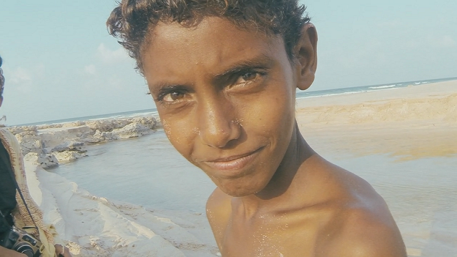 صورة لطفل يمني عاري الصدر على شاطئ البحر