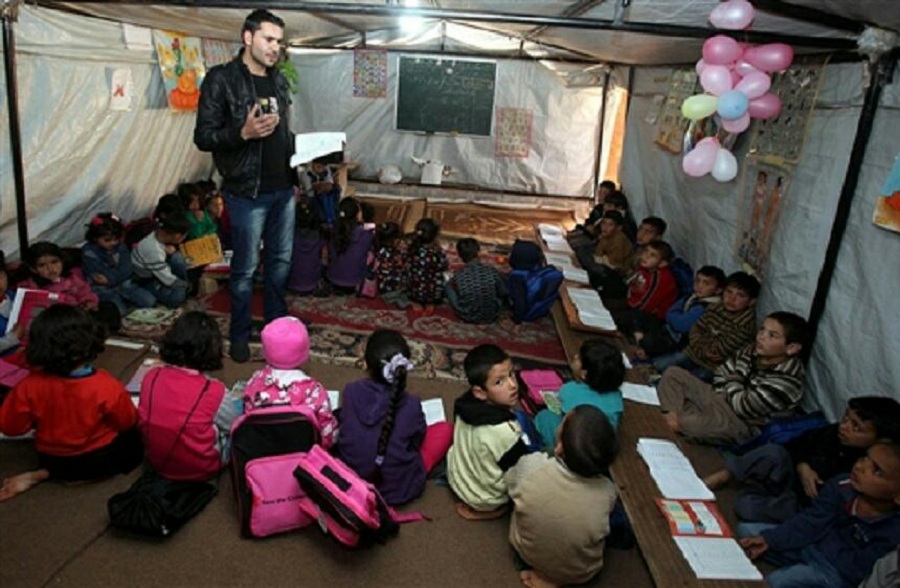 صورة الشاب ماجد يعطي درساً للأطفال داخل الخيمة