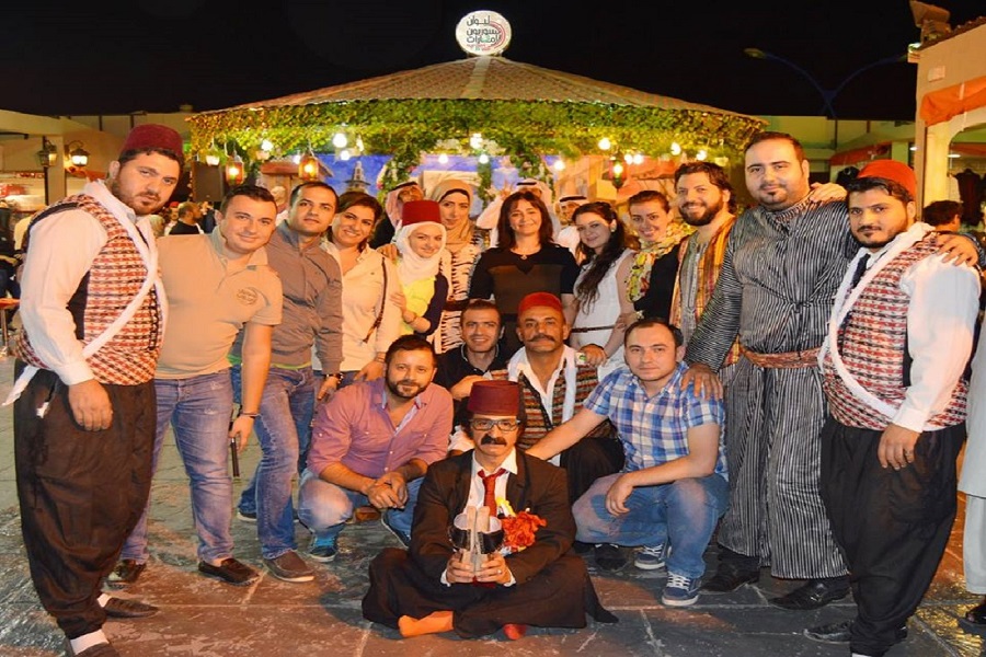 صورة المسؤولين عن صفحة السوريون في الإمارات أمام الليوان